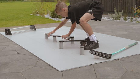 Player practising stickhandling on floorball tiles outdoors