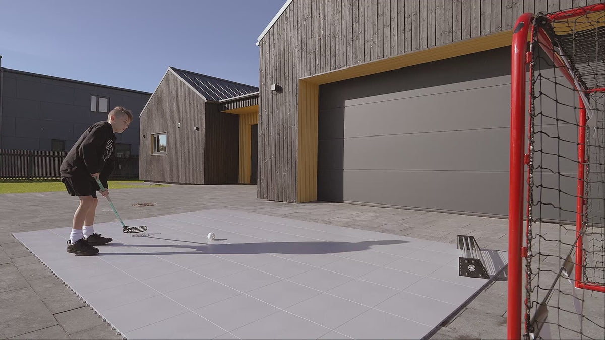 Home training zone with floorball tiles, passer and goal by the house