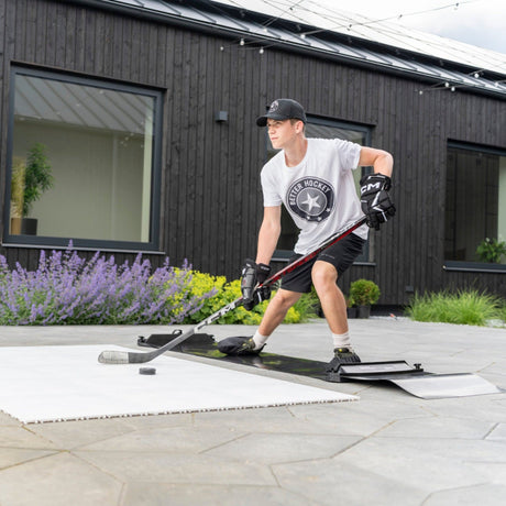 Hockey player in athletic stance on a slide board practicing lateral movement for off-ice training