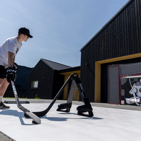 Hockey player working on puck handling around a Pro Defender in a garden training session