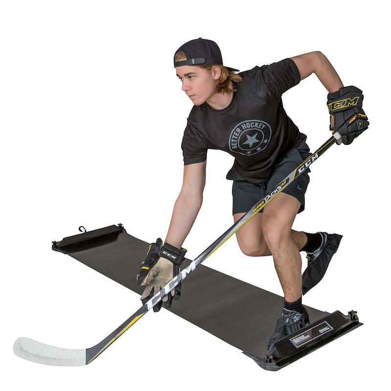 Hockey player in full gear using a slide board for off-ice training, showing lateral push mechanics